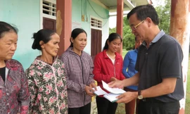 Đại diện lãnh đạo Tổng công ty Xây dựng số 1 trao tiền hỗ trợ cho người dân bị thiệt nặng tại huyện Quảng Ninh.