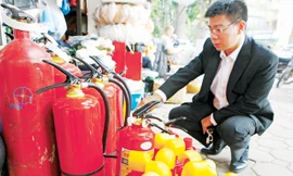 Trang bị bình cứu hỏa mini trên xe ô tô con hiện chỉ để đối phó. Trong ảnh: chọn mua bình cứu hỏa cho xe con ở Hà Nội. Ảnh: Như Ý.