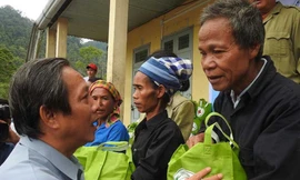 Bí thư Tỉnh ủy Quảng Bình (trái) tặng quà cho ông Đinh Nê, động viên dân bản đừng rời bản vào hang. Ảnh: Pháp luật TPHCM