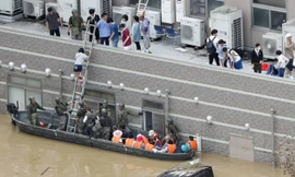 Các lực lượng phòng vệ đưa người dân ra khỏi vùng lụt tại tỉnh Okayama. Ảnh: Kyodo.