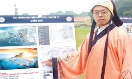 Phạm Sơn Tùng bên cạnh đồ án Làng nổi trên đảo chìm Đá Tây - Trường Sa.