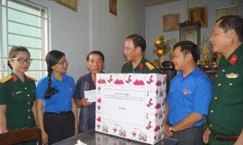 Thượng tá Ðinh Quốc Hùng, Trưởng ban Thanh niên Quân đội thăm hỏi, tặng quà cho thương binh Nguyễn Văn Chuyên. Ảnh: N.M.