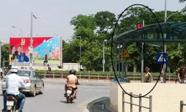 Đèn tín hiệu tại nút Giải Phóng-Đại Cồ Việt bị che khuất, CSGT đứng sau cột đèn này làm nhiệm vụ (vòng tròn).