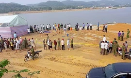 Nhiều người tập trung trên bờ xem khám nghiệm hiện trường. Ảnh: Đ.H. 