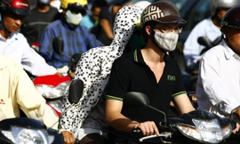 Người dân Hà Nội ra đường phải đối phó với khói bụi. Ảnh: Hồng Vĩnh.