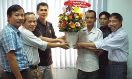 Nhà báo Nguyễn Đình Quân (thứ hai từ trái sang) cùng các đồng nghiệp Tiền Phong nhận lẵng hoa cám ơn từ “người tù thế kỷ” Huỳnh Văn Nén - người được anh Quân cùng đồng nghiệp kiên trì giải oan