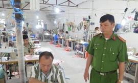 Trung tá Lâm Văn Lợi cùng các phạm nhân làm việc tại xưởng may.