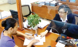 Trung ương vừa ra nghị quyết về tiếp tục đổi mới, sắp xếp lại tổ chức bộ máy tinh gọn, hiệu quả (Trong ảnh: Người dân làm thủ tục tại bộ phận một cửa tại UBND quận Ba Đình, Hà Nội). Ảnh: Như Ý.