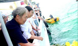 Bà Doãn Thị Mai và chị Doãn Thị Thu xúc động trong lễ thả hoa tưởng niệm các liệt sĩ tàu C235 trên biển.