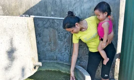 Từ khi dự án mỏ sắt Thạch Khê (Hà Tĩnh) khởi công, nguồn nước ở các xã bị cạn kiệt, bà Trương Thị Tuyết (thôn Liên Hải, Thạch Hải) bên những can nước mưa gia đình vừa tích trữ được. Ảnh: Minh Thùy.