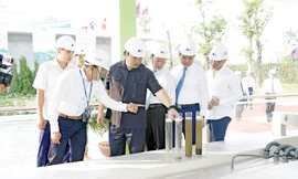 Bí thư Thành ủy Hà Nội Hoàng Trung Hải (thứ 4 từ phải qua) kiểm tra quá trình xử lý nước thải.