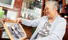 Bà Lịch xem lại những tấm ảnh kỷ niệm thời chiến.