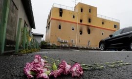 Một số người đã tới đặt hoa tưởng niệm các nạn nhân bên ngoài tòa nhà bị cháy. Ảnh: Reuters ​