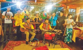 Tác giả bài viết đánh đàn ghi ta trên thuyền phục vụ khách du lịch trên sông Sài Gòn 