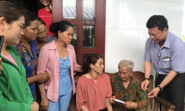 Ông Trương Quốc Lâm, Trưởng phòng LÐ- TB & XH huyện Ðông Hải trao quà hỗ trợ cho chị Hon