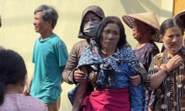 Người mẹ bị con tưới xăng đốt nhà ở Hưng Yên được người dân đưa ra khỏi hiện trường vụ hỏa hoạn.