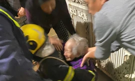 Cụ bà 94 được cảnh sát cõng ra khỏi hiện trường vụ hỏa hoạn lúc rạng sáng. 