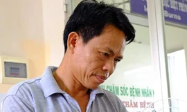 Ông Viêm chăm sóc con trai tại Bệnh viện Chợ Rẫy. Ảnh: Lê Phương. 