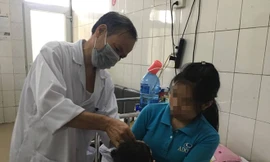 Bác sĩ Tâm thăm khám cho bệnh nhi bị bại não. Ảnh: Hà Quyên. 