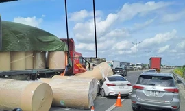 Nhiều cuộn giấy trên xe đầu kéo rơi xuống đường, đè trúng ô tô con