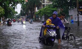 Mưa trắng trời giờ tan tầm, người dân TPHCM bì bõm lội nước về nhà