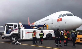 Lực lượng chức năng tiến hành kéo chiếc máy bay của Vietjet gặp sự cố khỏi đường băng. Ảnh: Hoàng Thiên Nga.