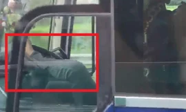 Tài xế xe khách dùng chân điều khiển xe đã bị người đi đường ghi lại clip. Ảnh cắt từ clip.