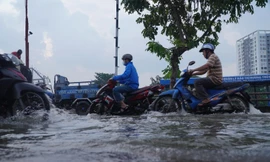 Người dân TPHCM bì bõm về nhà khi triều cường dâng cao