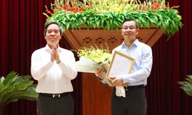 Đồng chí Nguyễn Văn Bình trao quyết định và chúc mừng đồng chí Ngô Văn Tuấn. 