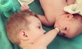 Xúc động khi bé trai 3 tuổi không tay chân dỗ dành em trai sơ sinh