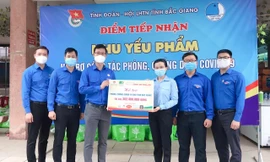 Chị Nguyễn Phạm Duy Trang, Trưởng ban Công tác Thiếu nhi T.Ư Đoàn, Phó Chủ tịch thường trực Hội đồng Đội T.Ư trao tặng bảng tượng trưng Hỗ trợ phòng, chống COVID-19 cho tỉnh Bắc Giang gồm nhu yếu phẩm, với tổng trị giá gần 303 triệu đồng.