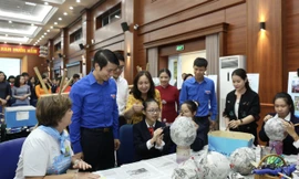 Anh Nguyễn Ngọc Lương, Bí thư T.Ư Đoàn, Chủ tịch Hội đồng Đội T.Ư (thứ hai, từ trái qua) xem học sinh Hà Nội làm các sản phẩm tái chế trong khuôn khổ chương trình trao giải cuộc thi ảnh "Việc tốt vì trẻ em". ẢNH: BẢO ANH