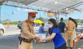 Chị Chu Hồng Minh, Bí thư Thành Đoàn Hà Nội trao tặng nước uống cho lực lượng trực tại các đểm chốt kiểm soát của Thủ đô