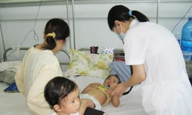 Bác sĩ khám cho bệnh nhi mắc TCM tại BV Nhi T.Ư. Ảnh:T.Hà