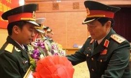 Thượng tướng Ngô Xuân Lịch (bên phải), Bí thư T.Ư Đảng, Chủ nhiệm Tổng cục Chính trị trao bằng khen và tặng hoa chúc mừng Trung úy Hoàng Văn Đông, tháng 3/2014. ảnh: NGUYỄN MINH