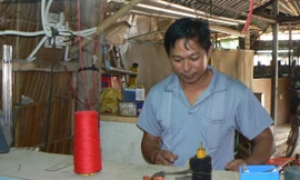 Anh Nguyễn Văn An đang sửa máy đan len. ẢNH: TÙNG HUYÊN