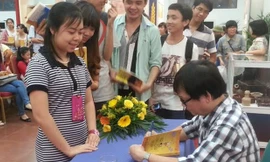 Nguyễn Nhật Ánh ký sách ở Hà Nội. Ảnh: T.Quý 