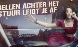 Một tấm áp phích cảnh báo nguy hiểm khi vừa lái xe vừa nghe điện thoại