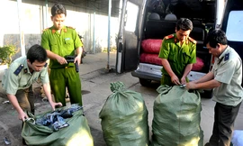 Các cơ quan chức năng kiểm tra các bao hàng chứa súng nhựa trên xe chở khách. Ảnh: VnExpress