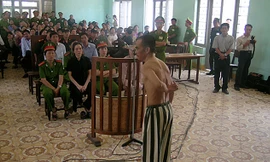 Ông Huỳnh Văn Nén cởi áo, chỉ những vết sẹo mà ông nói là do bị đánh trong tù, tại phiên tòa phúc thẩm (lần 3) “Vụ án vườn điều” ngày 9/3/2005. Ảnh: Nguyễn Đình Quân 