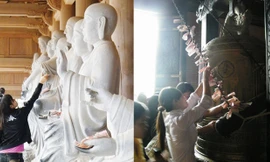 Tại chùa Bái Đính, người ta không chỉ “lót tay” tượng mà còn cài tiền lẻ lên dây treo chày gõ chuông - như một trò vui. ảnh: N.M.Hà