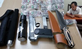 Trần Thanh Bình và số vũ khí mà đối tượng mua ở Lào Cai. Ảnh: L.D