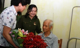 Các cựu nữ TNXP và thành viên chương trình “Hát mãi ca khúc bài ca cô gái mở đường” tặng hoa nhạc sĩ Xuân Giao. Ảnh: Mai Xuân Tùng