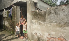 Chị Nhâm và hai con trước căn nhà xuống cấp. Ảnh: K.N