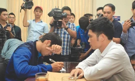 Hậu vệ Phan Lưu Thế Sơn (Đồng Nai) che mặt viết tường trình tại cơ quan công an trước ống kính của báo chí. Ảnh: Tuấn Tú