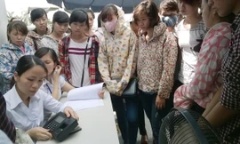 Ứng viên lấy dấu vân tay trước khi vào thi tuyển công nhân