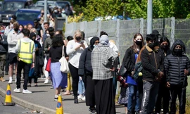 Những người xếp hàng đợi xét nghiệm COVID-19 và tiêm vắc-xin tại thành phố Bolton, một 'điểm nóng' về COVID-19 tại Anh trong những ngày gần đây. Ảnh: Getty.