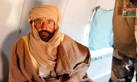 Ông Saif được đưa lên máy bay sau khi bị bắt.	Ảnh: Reuters