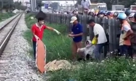 Lực lượng chức năng đang giải quyết vụ tai nạn, đưa nạn nhân ra khỏi khu vực đường tàu