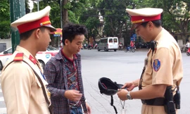 Lực lượng CSGT nhắc nhở người tham gia giao thông phải đội mũ bảo hiểm đạt chuẩn. Ảnh: Tuấn Nguyễn